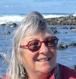 Windswept lady long grey hair sea in background 